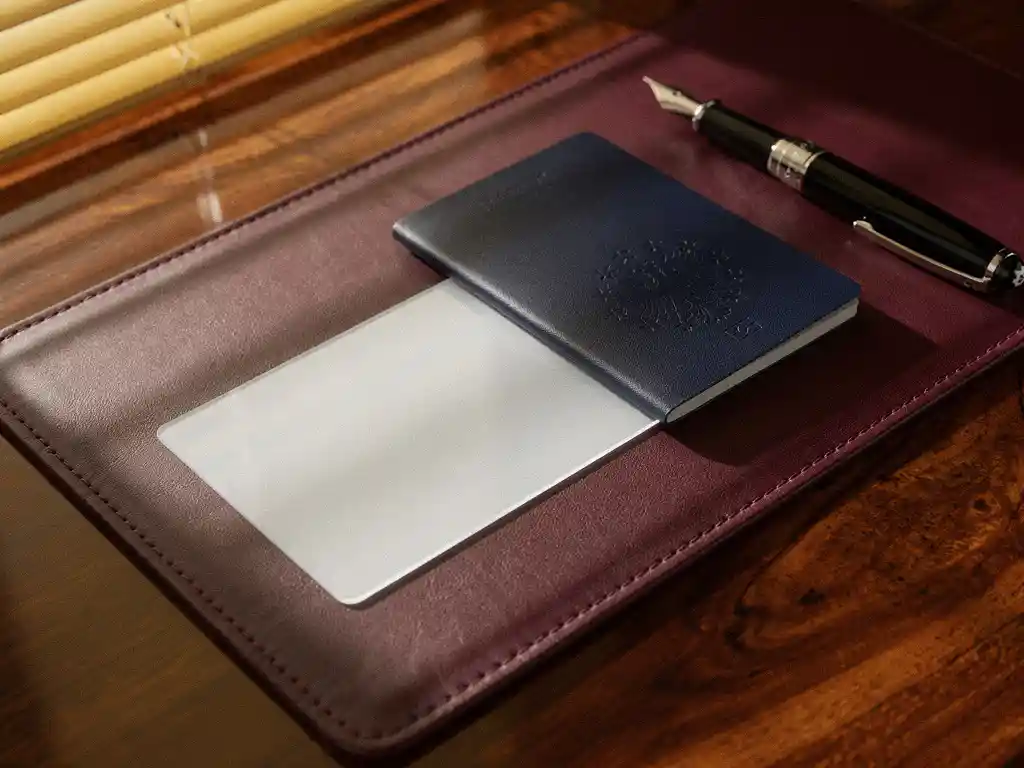 EU Blue Card document en Europees paspoort op mahoniehout bureau met Mont Blanc vulpen, gouden zonlicht door jaloezieën